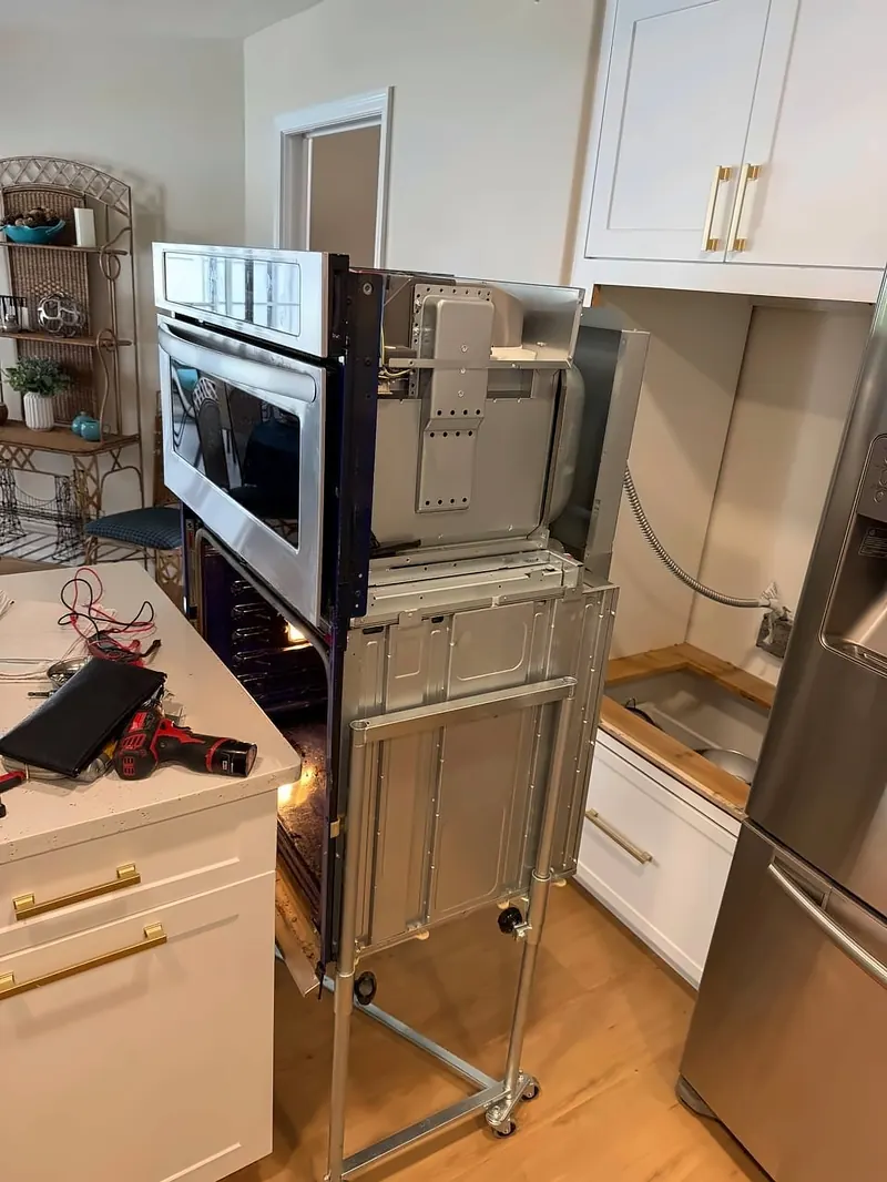 A built-in wall oven pulled out for service
